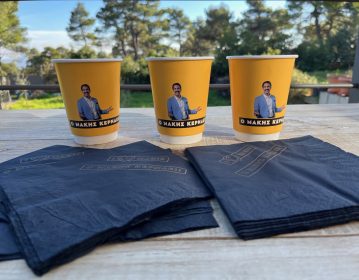 OPAP Allwyn, yellow cup & black paper napkin